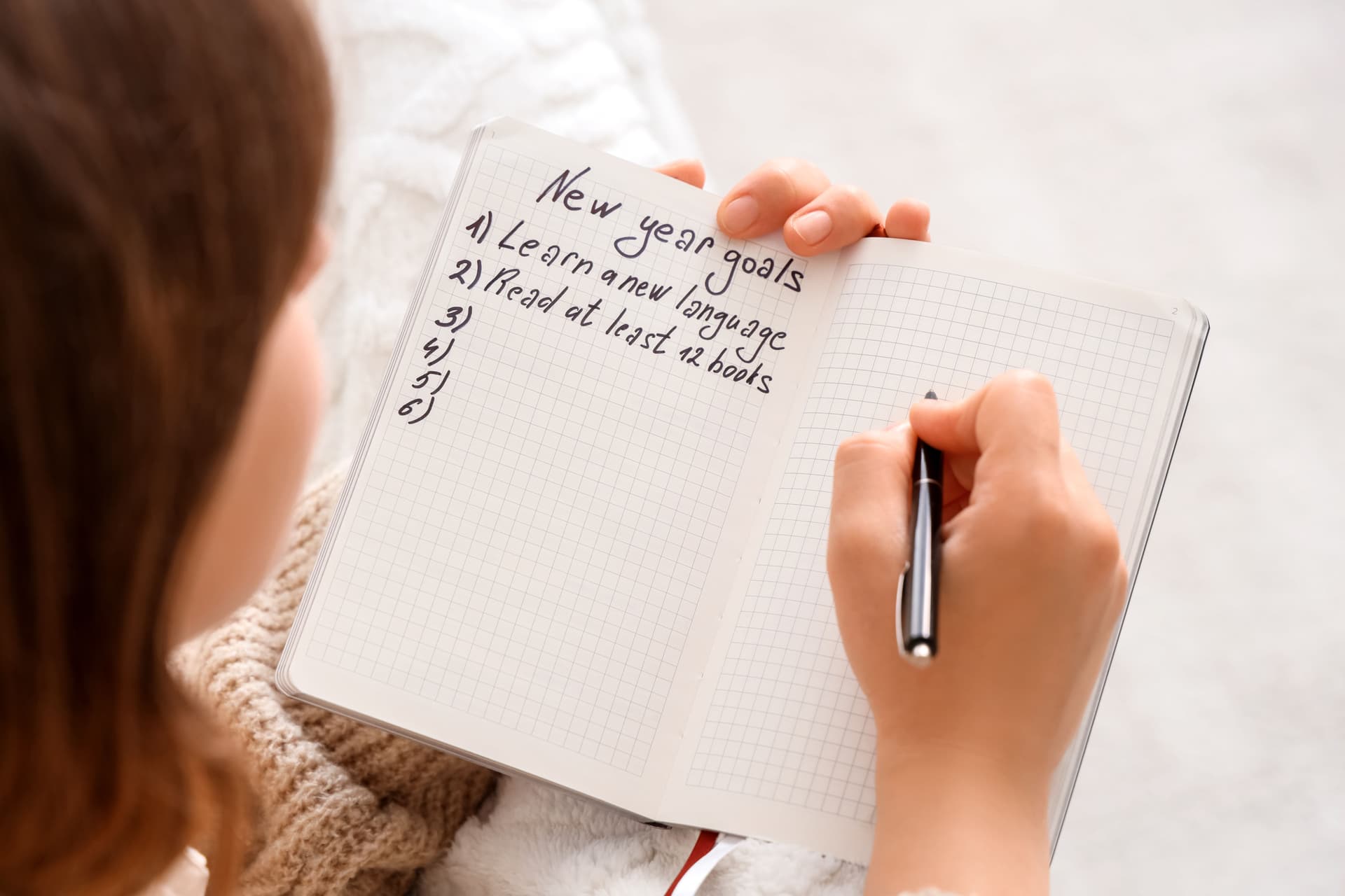Person crossing out failed New Year's resolutions